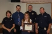 (from left to right):  Officer Christine Peterson (uniform), Officer Brian Stahl (shirt and tie), Jessica Taylor-Weiss (with framed certificate and medal), Detective Shawn Houck (uniform), and Sergeant Mike Mann (plain clothes)