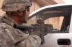 Soldier from the military transition team assigned to 2nd Brigade, 2nd Iraqi Army Division takes cover behind a vehicle during a firefight in Mosul, Iraq