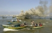 Palestinian fishermen gather around a fishing boat after it was hit by Israeli army naval fire at Gaza's seaport. 