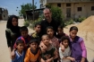 Ken O'Keefe and interpreter Noor Ahmed with the Samouni family children in Gaza, 2011.