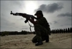 A woman fighter of the Tamil Tigers takes a shooting position in Sri Lanka in July 2007