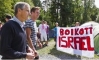 Reuters photo of Jonas Gahr Store passing a sign promoting the boycott of goods from Israel's occupation settlers.