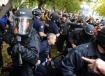 An officer pointing a weapon at a photographer earlier in the day