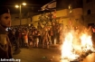 A crowd starting a fire on the main road of Hatikva (Activestills)