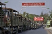 Army trucks line up along a road in downtown Meikhtila