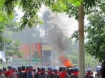 Military and a backdrop of a burning Rohingya village