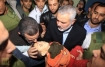 Palestinian Hamas leader in the Gaza Strip Ismail Haniya (R) and Egyptian Prime Minister Hesham Kandil hold the body of a Palestinian baby boy who was killed in an Israeli air strike