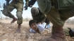 Israeli soldiers take down a small Palestinian boy.