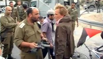 Israeli Lieutenant-Colonel Eisner prepares to attack a a peace activist with his rifle