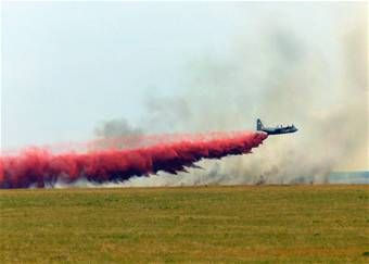 A C-130 Hercules aircraft drops fire retardant chemicals on a wildfire.  Photo: California Air National Guard