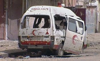 A destroyed Syrian Arab Red Crescent ambulance sits amid rubble in Homs